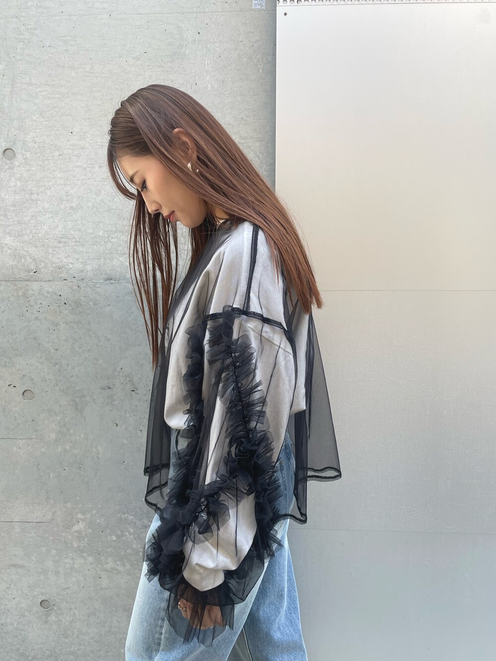 ブルー系のデニムパンツ、ブラック系のTシャツ/カットソー、ブラック系のトートバッグを着用したレディースの春コーディネートの3枚目の写真