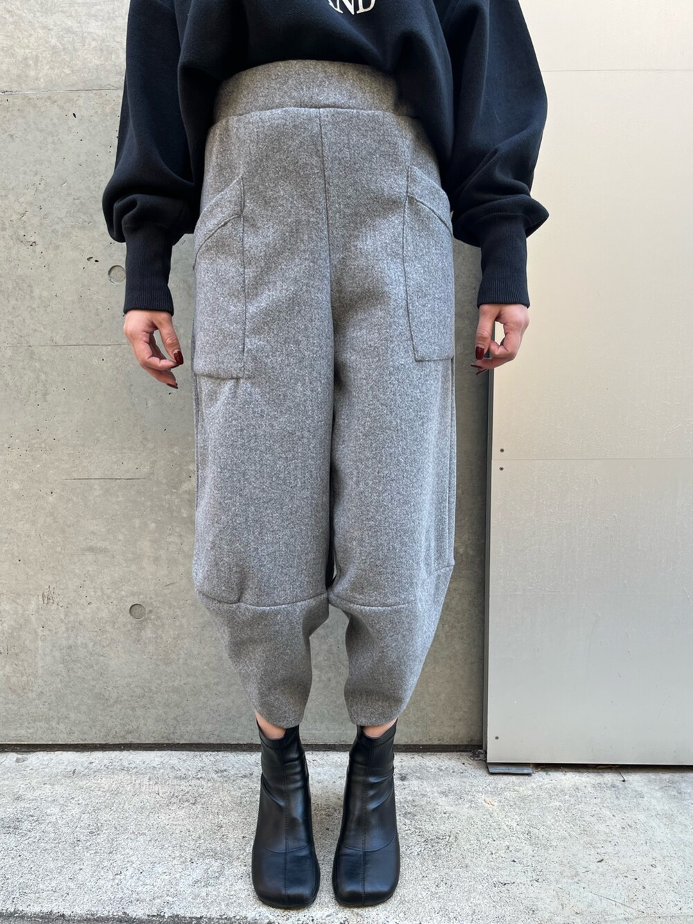 グレー系のその他パンツ、ブラック系のニット/セーター、ブラック系のハットを着用したレディースの冬コーディネートの4枚目の写真