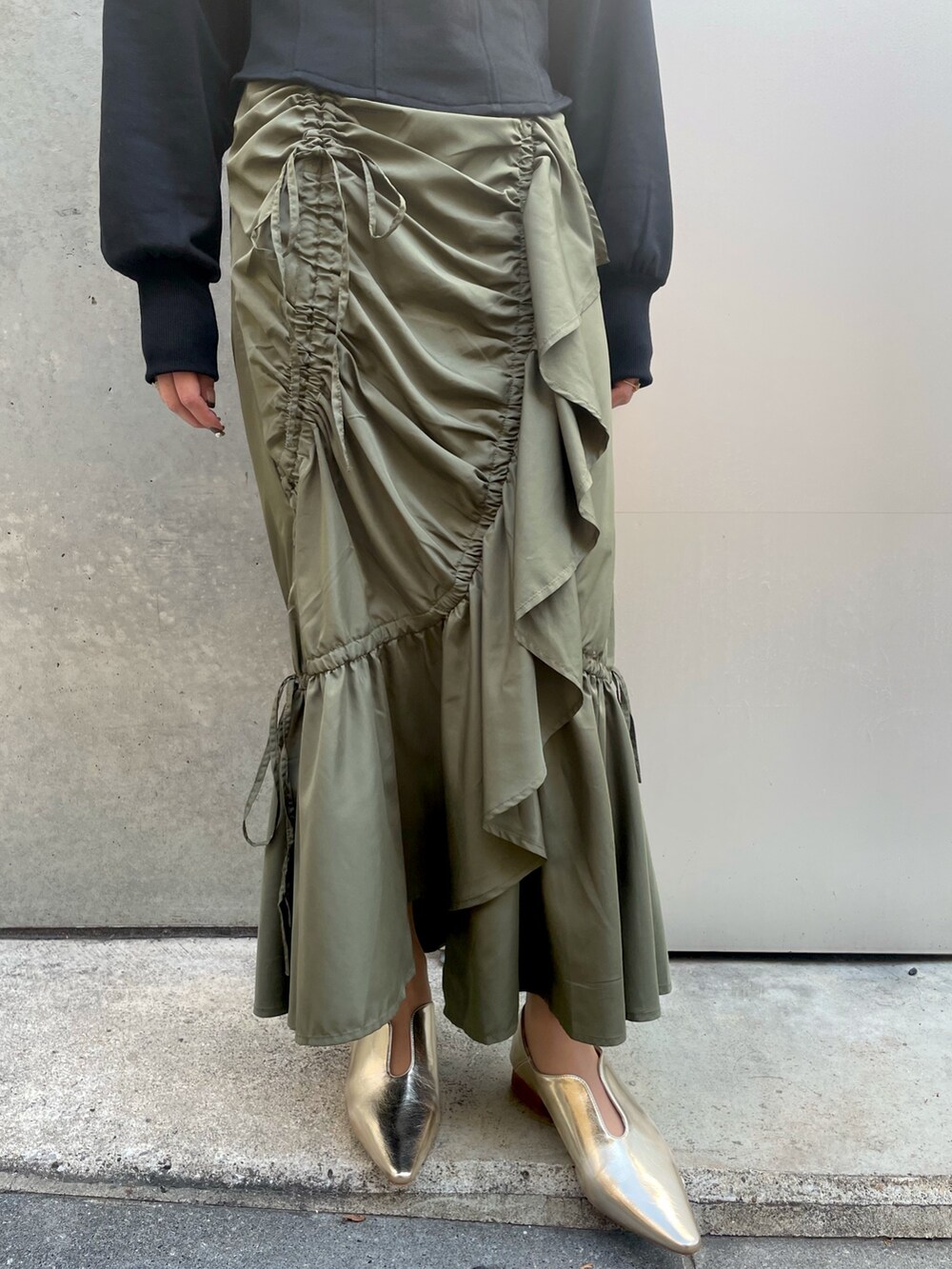 ブラック系のスウェット、グリーン系のスカートを着用したレディースの春コーディネートの4枚目の写真