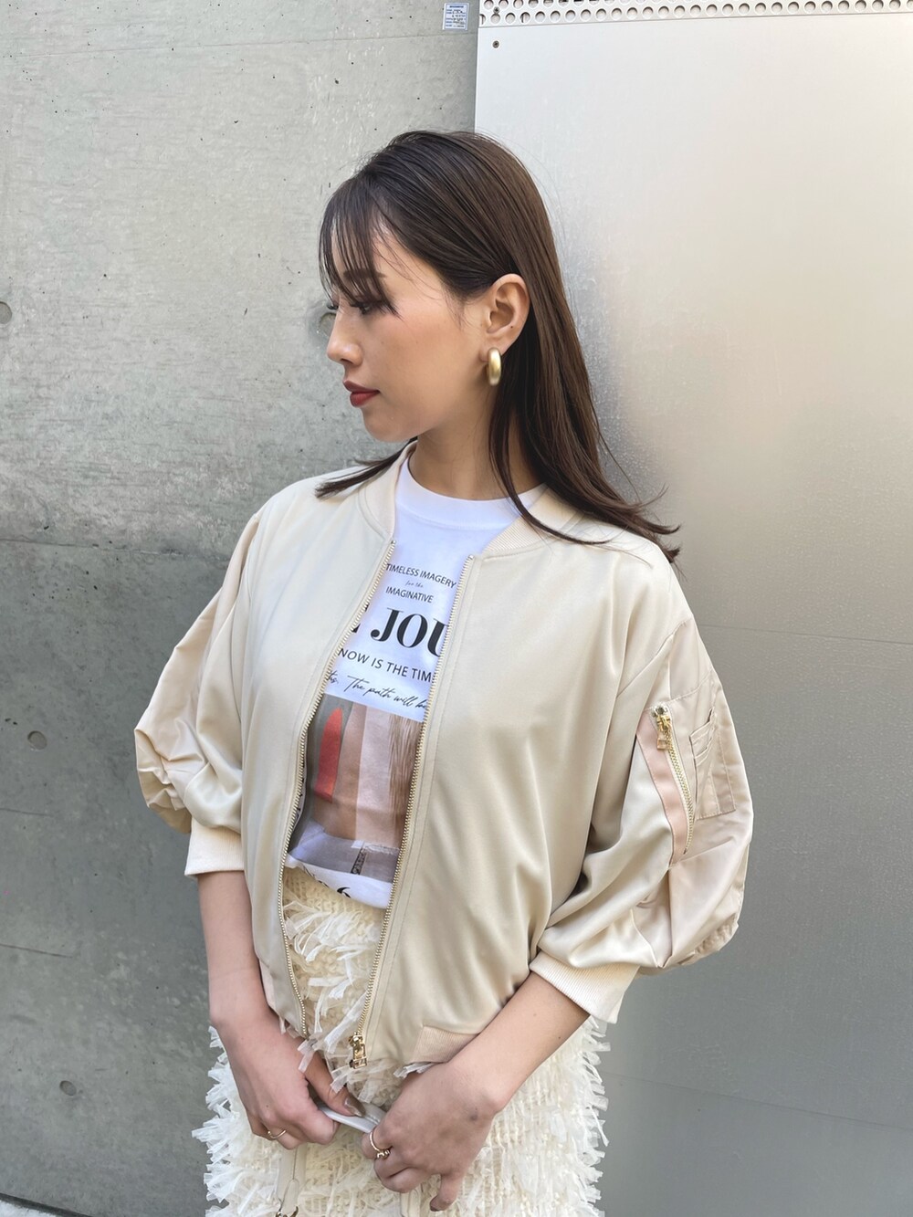 ホワイト系のバッグ、ブラック系のローファー、ホワイト系のスカートを着用したレディースの春コーディネートの3枚目の写真