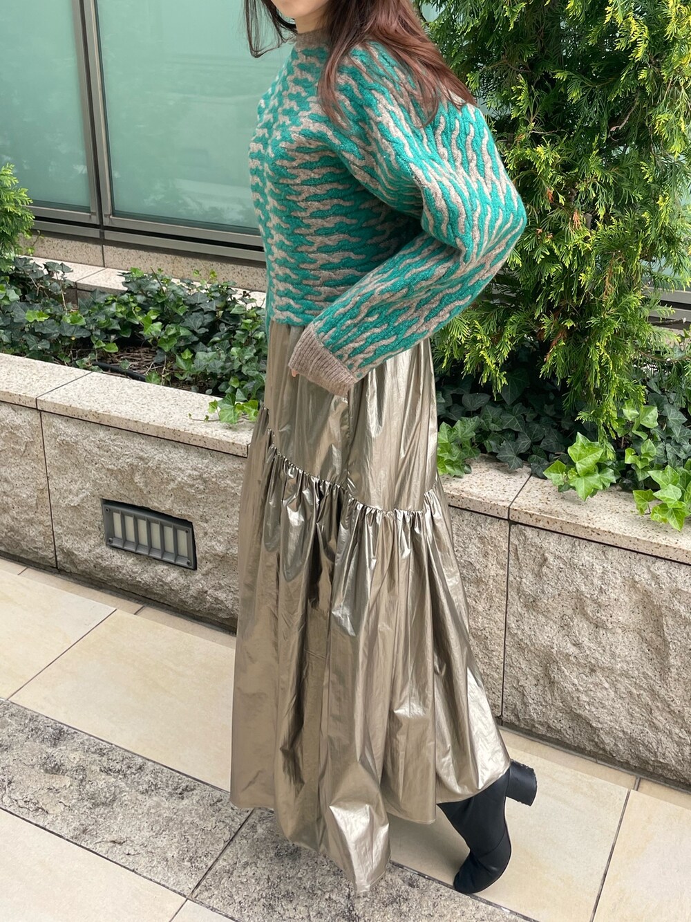 グリーン系のニット/セーター、ゴールド系のスカートを着用したレディースの秋コーディネートの5枚目の写真