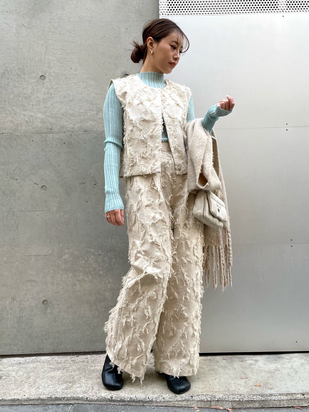 ホワイト系のその他パンツ、ホワイト系のベスト、グリーン系のTシャツ/カットソーを着用したレディースの冬コーディネートの3枚目の写真