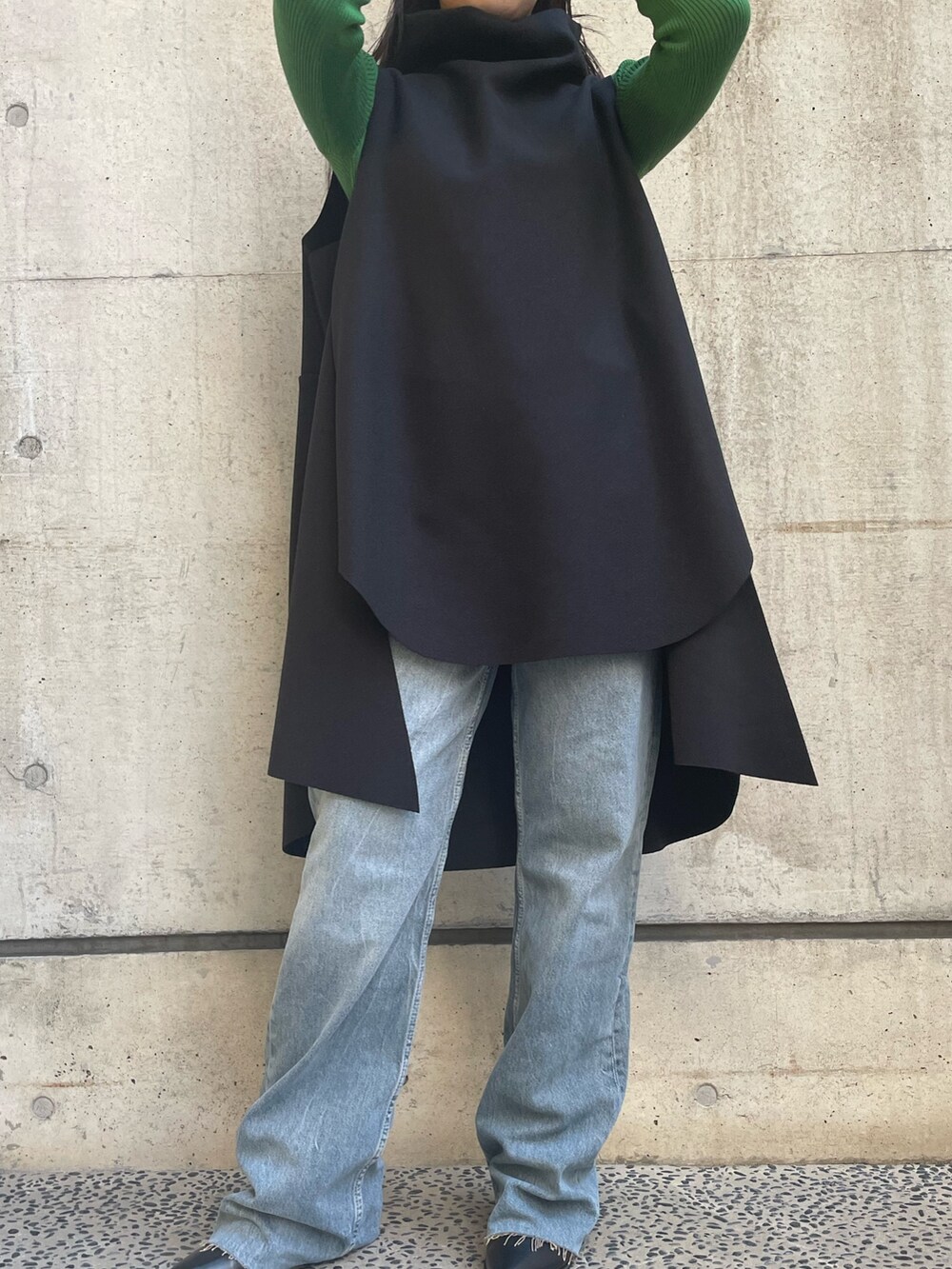 ブラック系のベスト、グリーン系のニット/セーターを着用したレディースの冬コーディネートの2枚目の写真