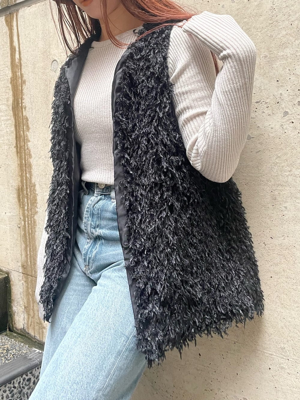 ブラック系のベスト、ホワイト系のニット/セーター、ブラック系のハットを着用したレディースの冬コーディネートの6枚目の写真