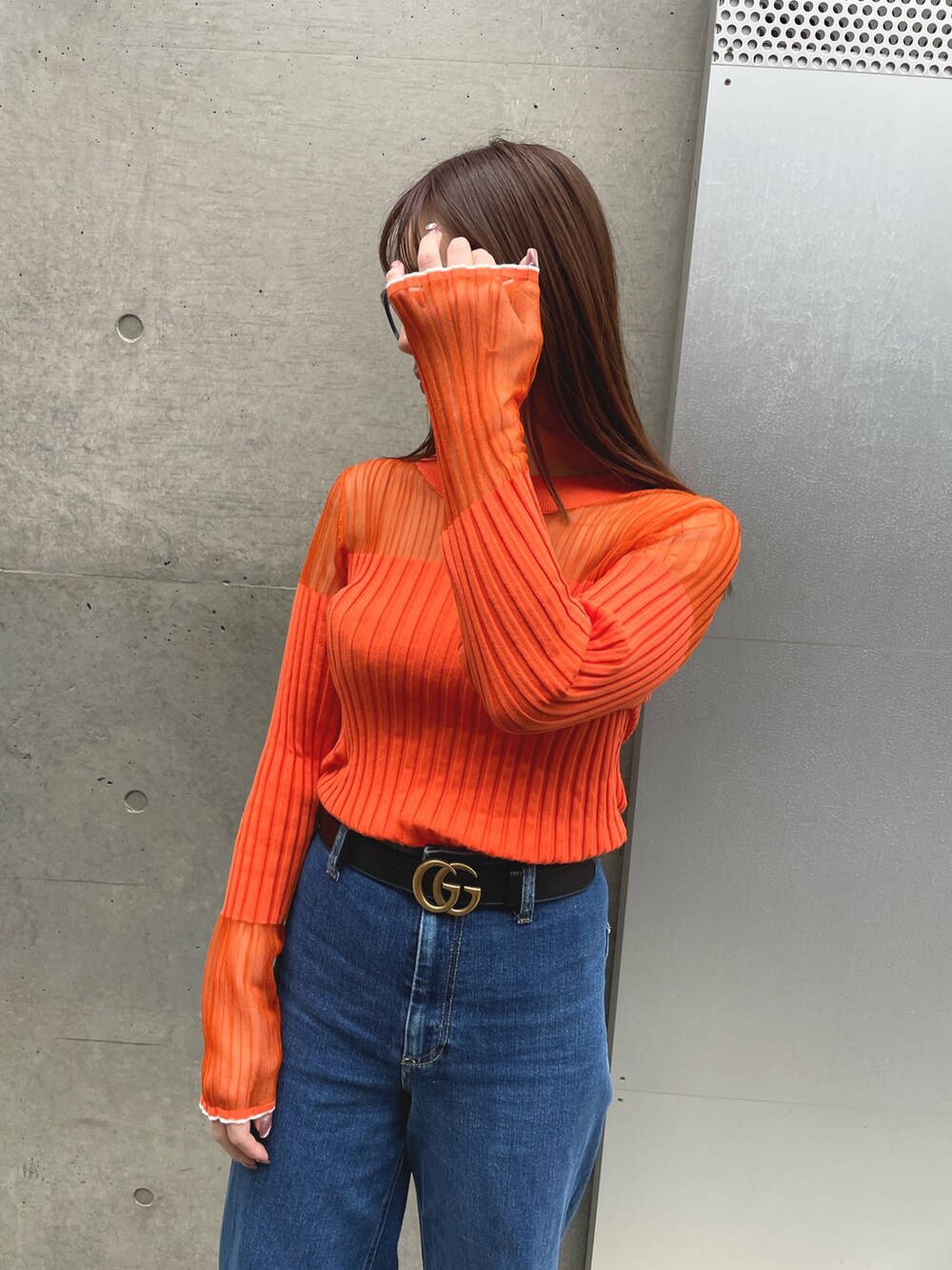 ベージュ系のジャケット/アウター、ブルー系のデニムパンツ、オレンジ系のニット/セーターを着用したレディースの冬コーディネートの3枚目の写真