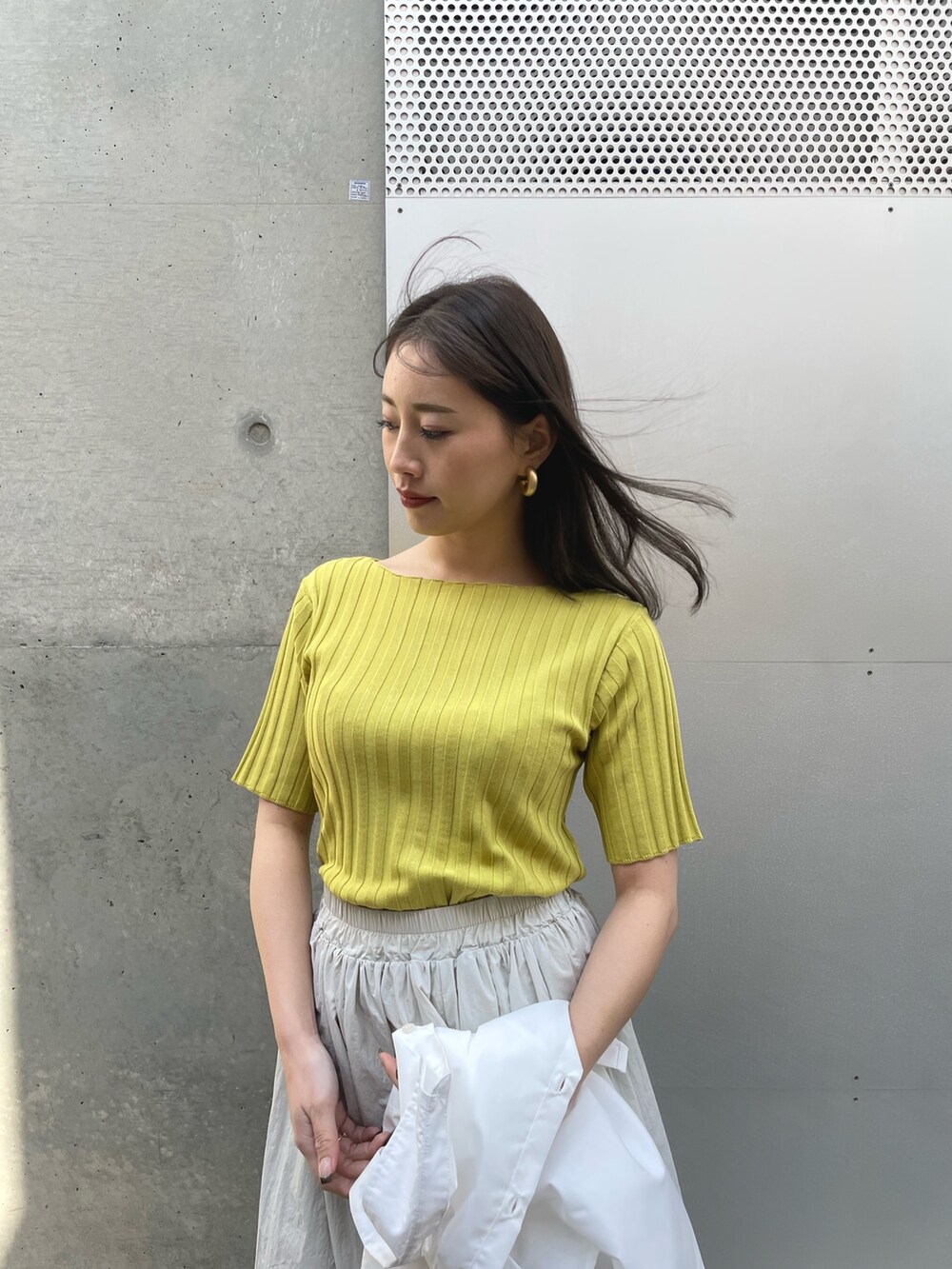 ブラック系のスニーカー、グレー系のスカート、ホワイト系のシャツ/ブラウスを着用したレディースの春コーディネートの5枚目の写真