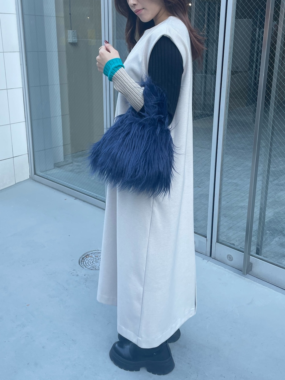 ブルー系のハンドバッグ、ブラック系のニット/セーター、ホワイト系のワンピースを着用したレディースの秋コーディネートの7枚目の写真