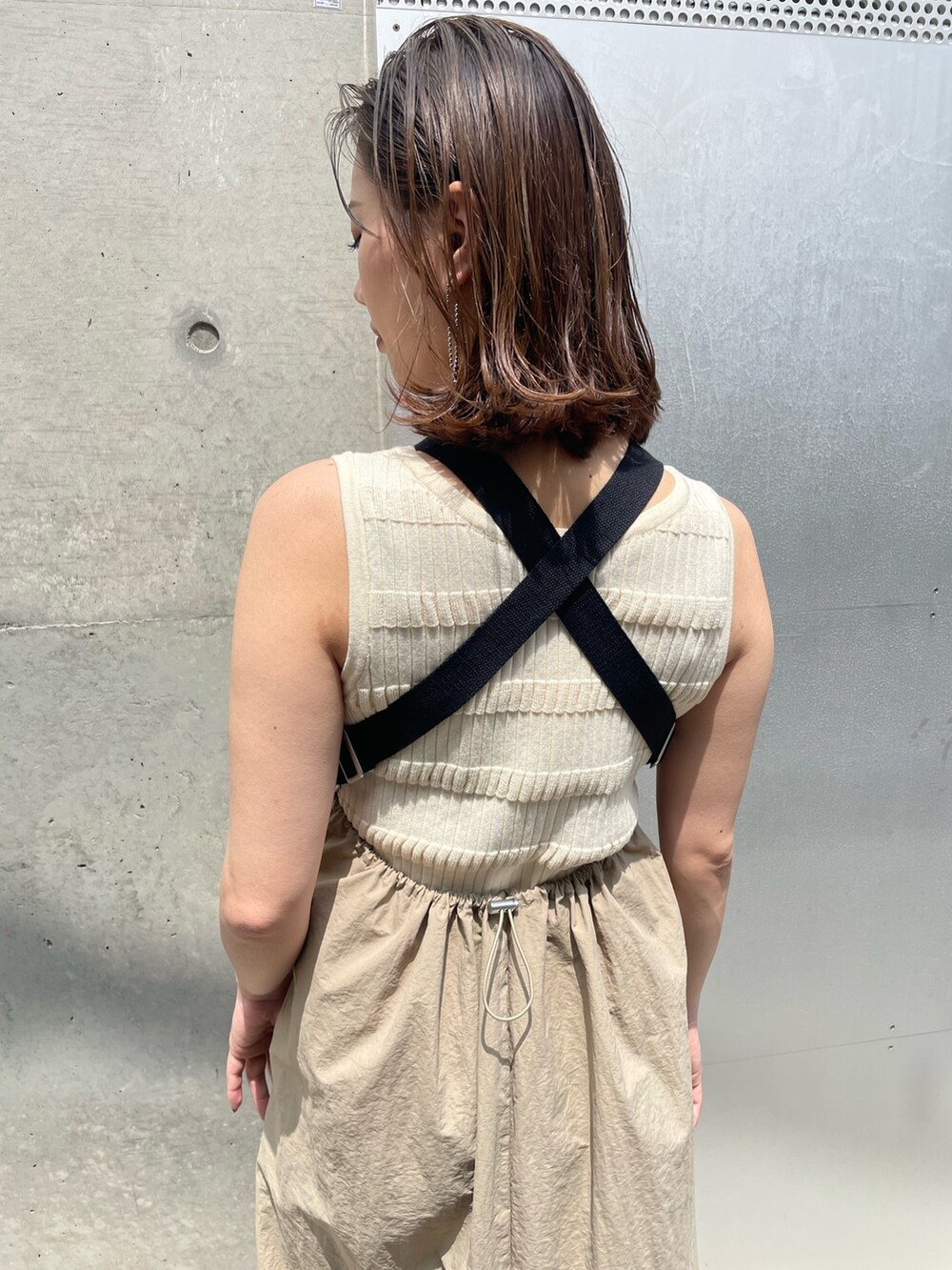 ホワイト系のニット/セーター、ベージュ系のワンピース、ブラック系のサンダルを着用したレディースの春コーディネートの4枚目の写真