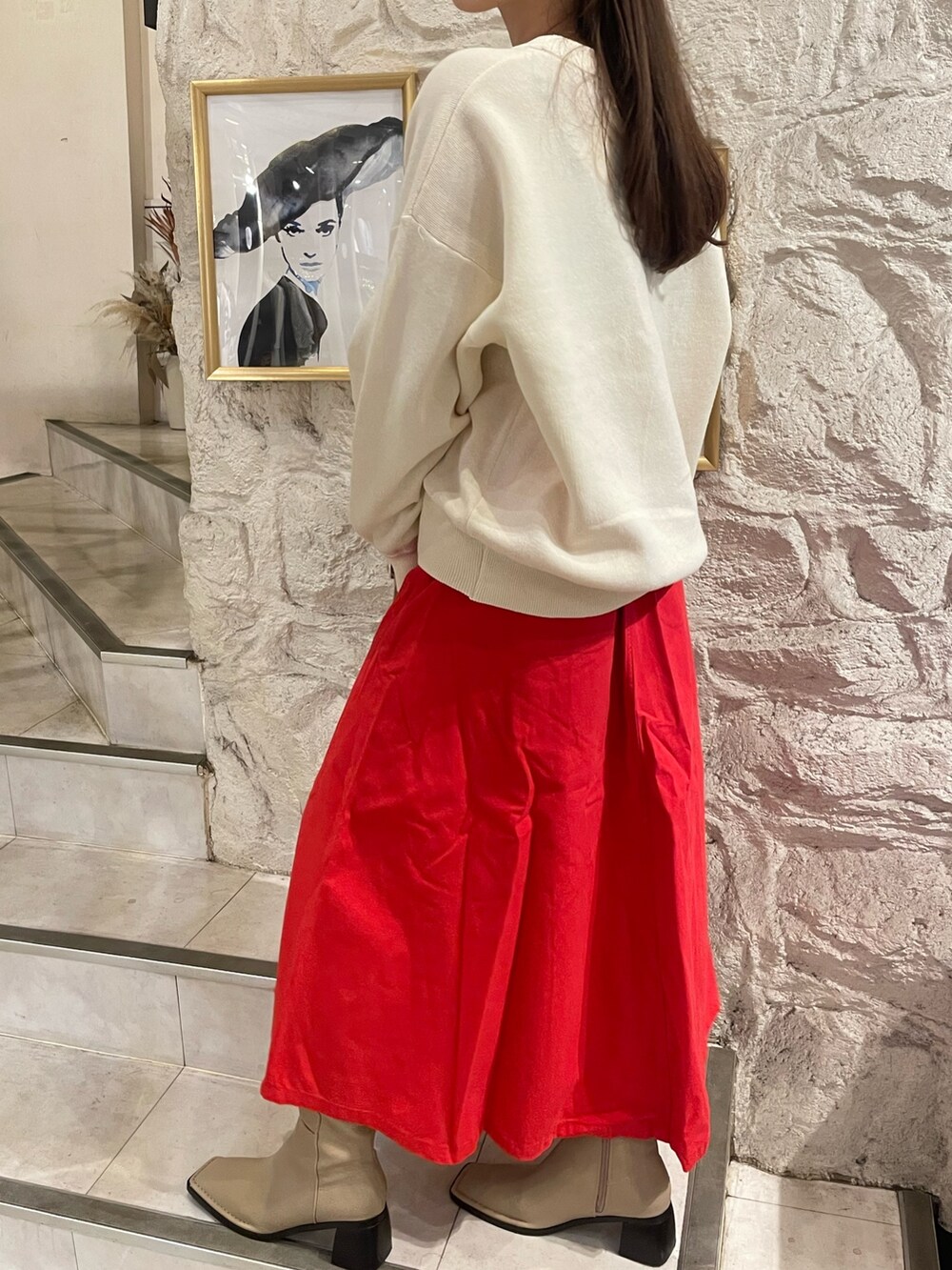 ホワイト系のニット/セーター、レッド系のスカートを着用したレディースの秋コーディネートの3枚目の写真