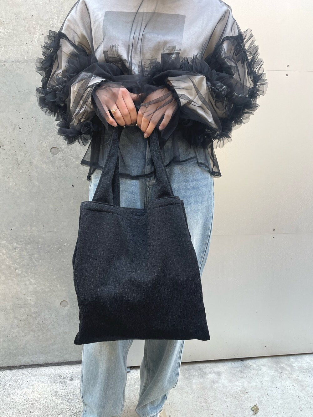 ブラック系のTシャツ/カットソー、ブラック系のトートバッグを着用したレディースの春コーディネートの6枚目の写真