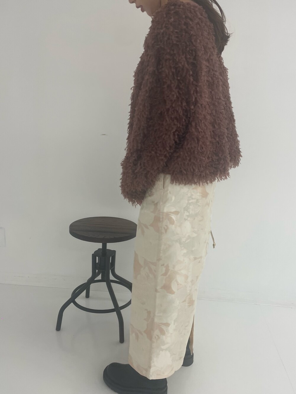 ゴールド系のトートバッグ、ホワイト系のスカート、ブラウン系のTシャツ/カットソーを着用したレディースの冬コーディネートの6枚目の写真