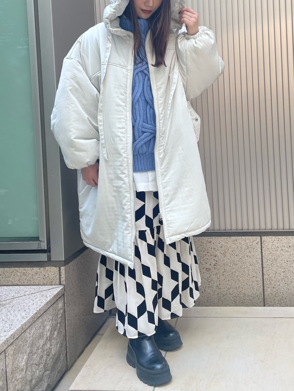 ブラック系のスカート、ブルー系のベスト、ホワイト系のシャツ/ブラウスを着用したレディースの冬コーディネートの2枚目の写真