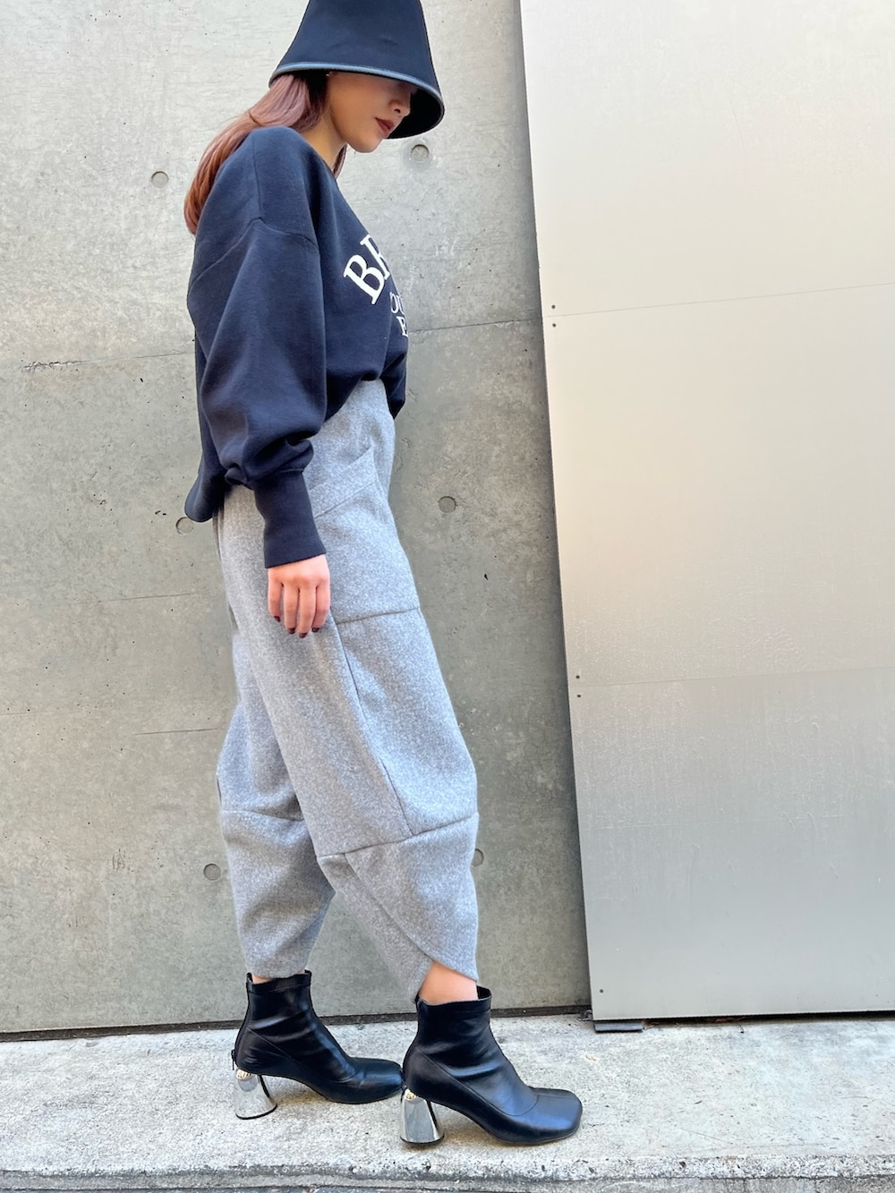 グレー系のその他パンツ、ブラック系のニット/セーター、ブラック系のハットを着用したレディースの冬コーディネートの2枚目の写真