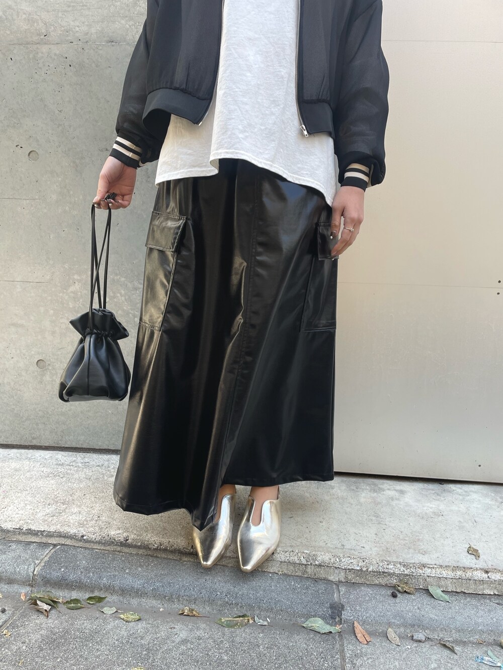 ブラック系のショルダーバッグ、ブラック系のスカート、ブラック系のブルゾンを着用したレディースの春コーディネートの5枚目の写真
