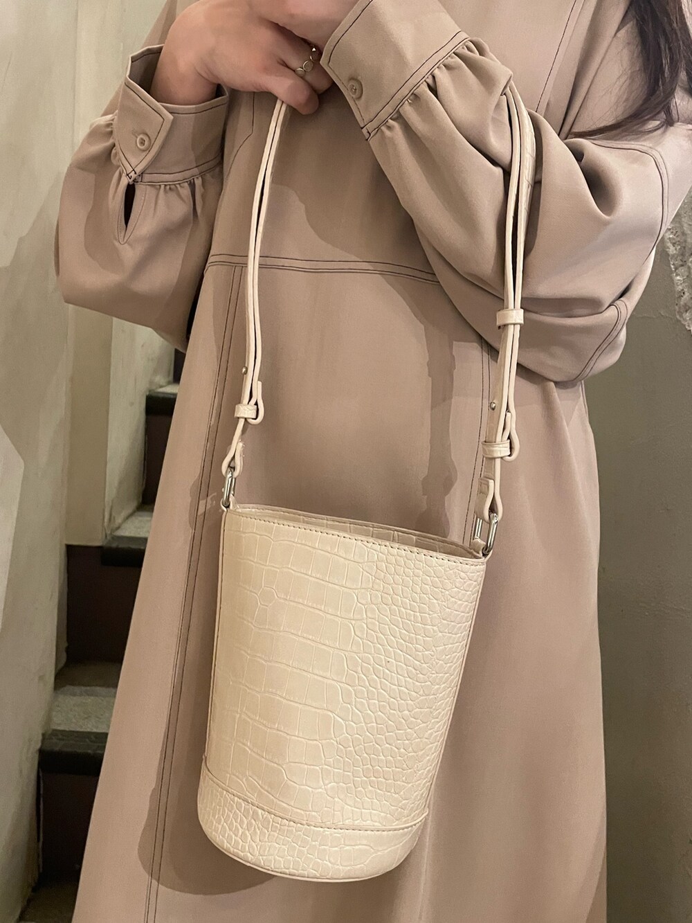 ホワイト系のショルダーバッグ、グレー系のワンピースを着用したレディースの冬コーディネートの10枚目の写真