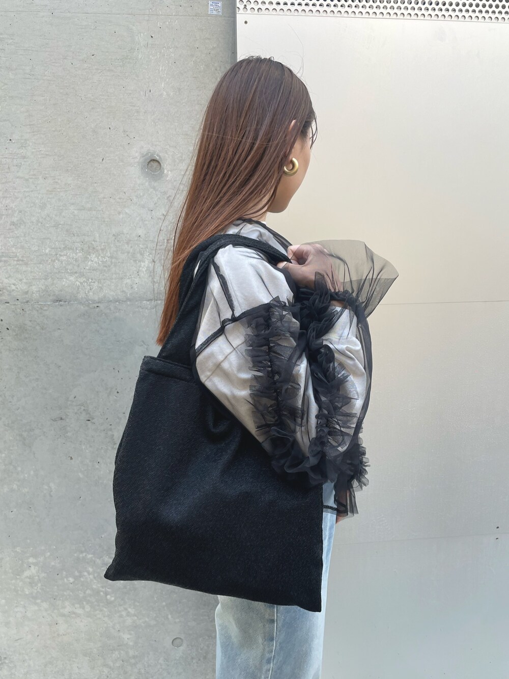 ブラック系のTシャツ/カットソー、ブラック系のトートバッグを着用したレディースの春コーディネートの5枚目の写真