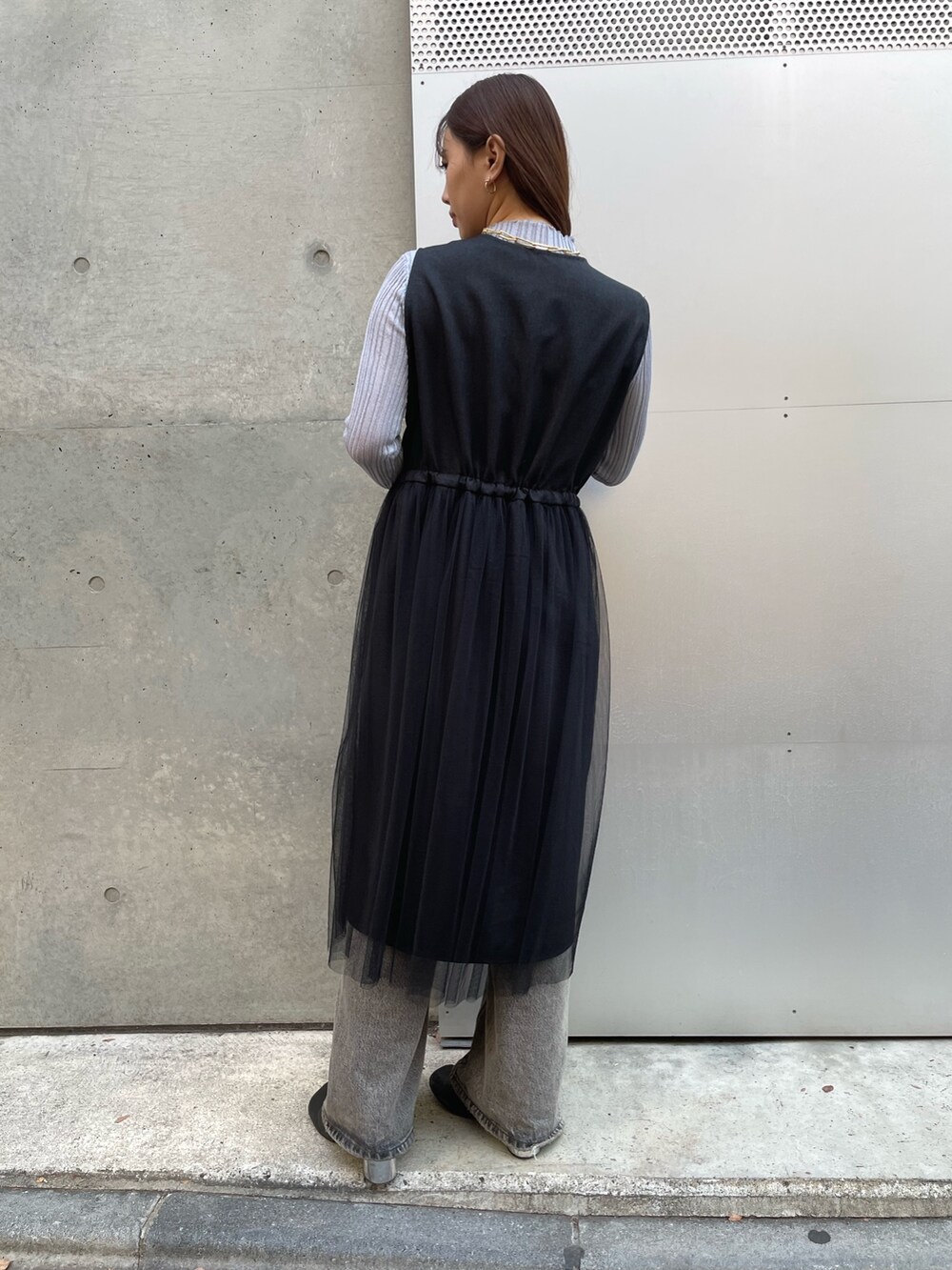 グリーン系のTシャツ/カットソー、ブラック系のベスト、グレー系のデニムパンツを着用したレディースの冬コーディネートの3枚目の写真