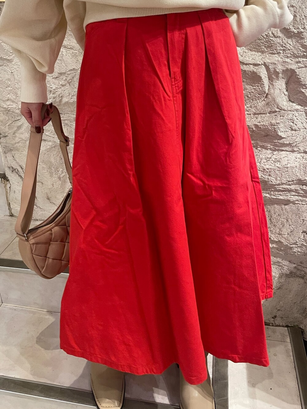 ホワイト系のニット/セーター、レッド系のスカートを着用したレディースの秋コーディネートの8枚目の写真