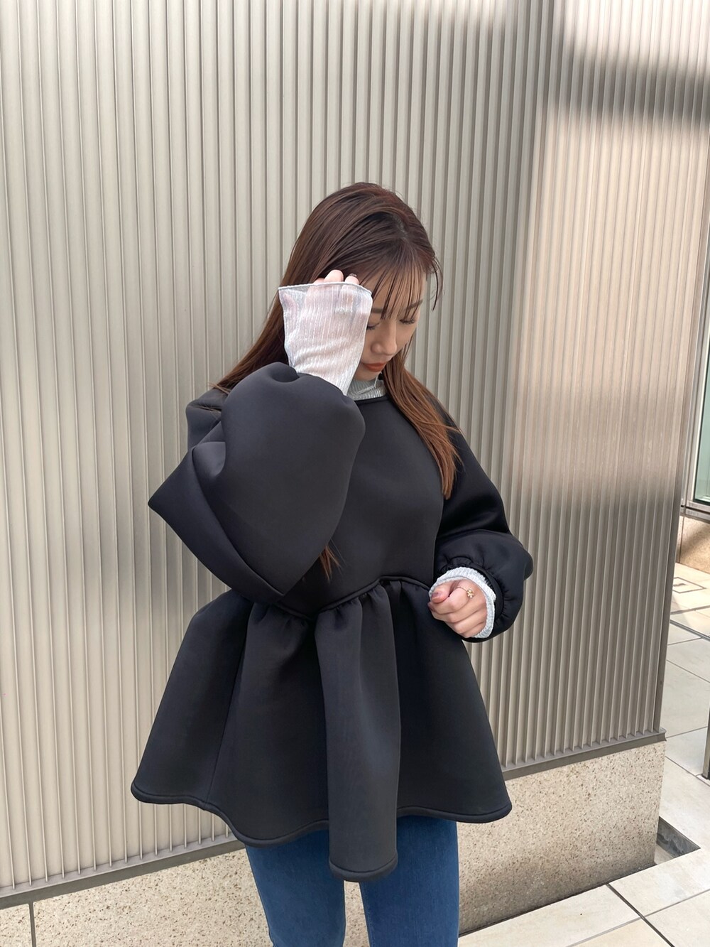 ブルー系のデニムパンツ、ブラック系のブーツ、シルバー系のTシャツ/カットソーを着用したレディースの冬コーディネートの3枚目の写真