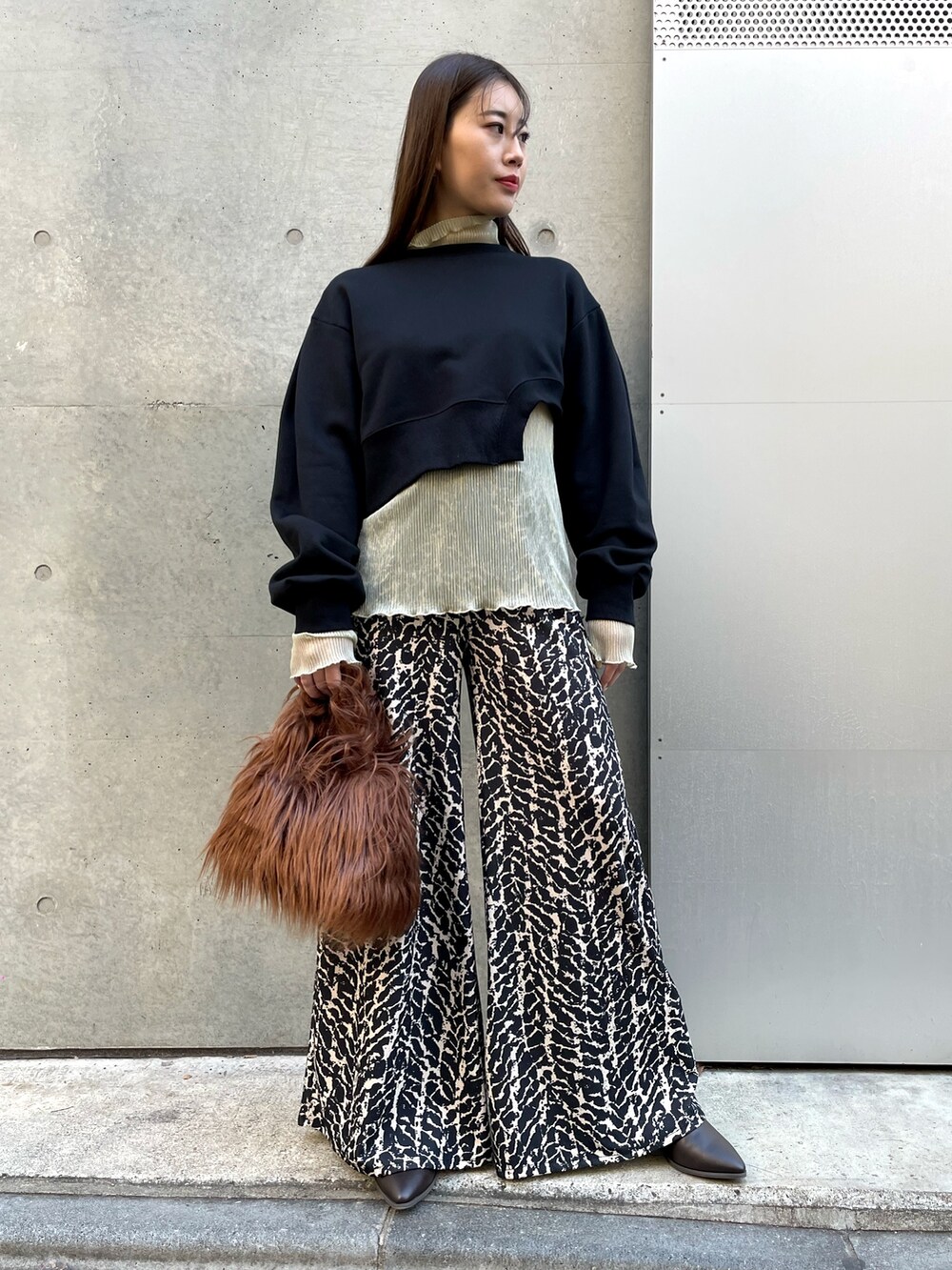 ブラウン系のハンドバッグ、ゴールド系のTシャツ/カットソー、ブラック系のその他パンツを着用したレディースの冬コーディネートの5枚目の写真