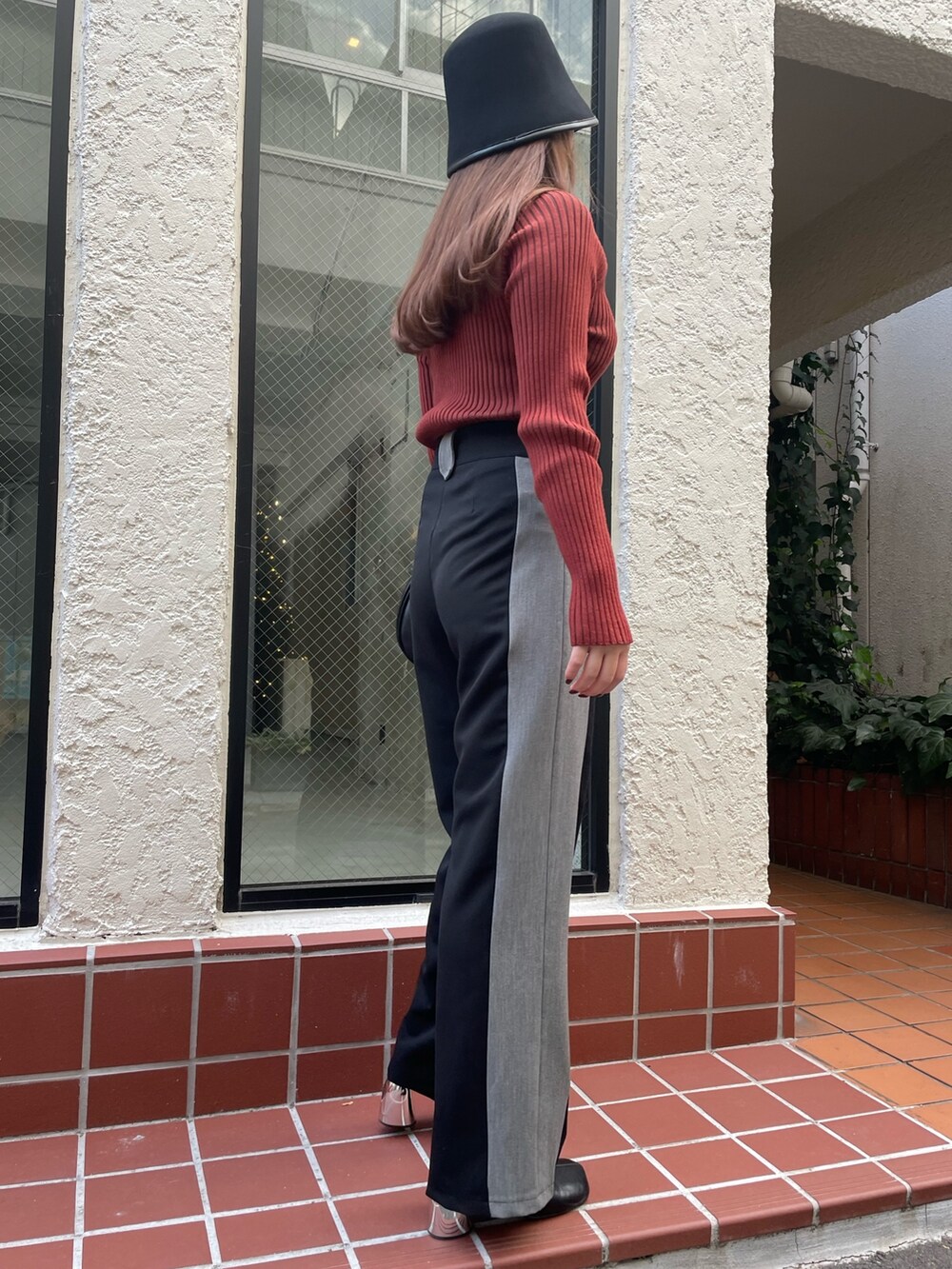 ブラック系のその他パンツ、ブラック系のショルダーバッグ、レッド系のニット/セーターを着用したレディースの冬コーディネートの5枚目の写真