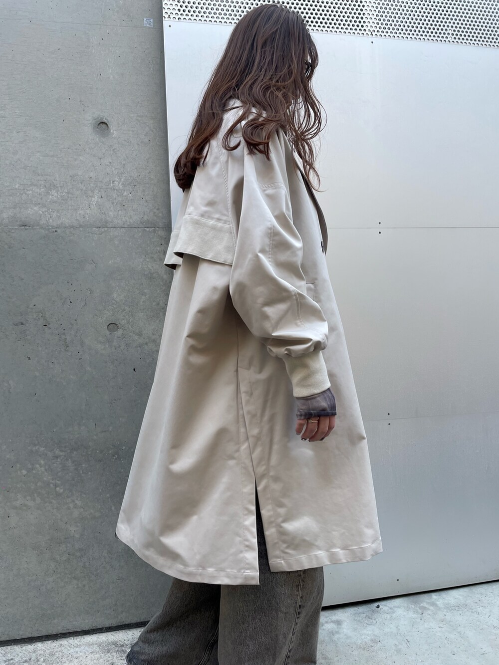 ベージュ系のトレンチコート、ブラック系のデニムパンツ、ホワイト系のスニーカーを着用したレディースの春コーディネートの3枚目の写真