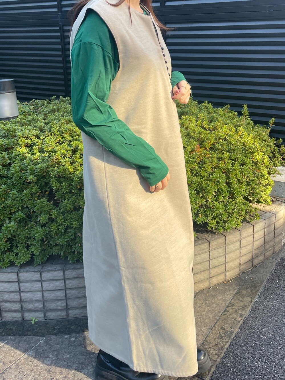 グリーン系のTシャツ/カットソー、ベージュ系のワンピースを着用したレディースの冬コーディネートの2枚目の写真