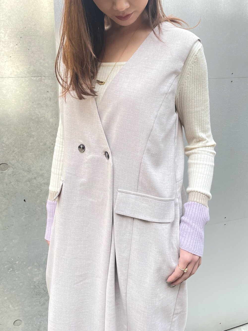 ブラック系のパンプス、ベージュ系のワンピース、ホワイト系のニット/セーターを着用したレディースの春コーディネートの3枚目の写真