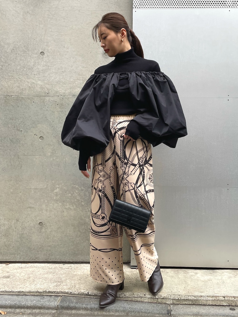 ベージュ系のその他パンツ、ブラック系のショルダーバッグ、ブラック系のカーディガン/ボレロを着用したレディースの冬コーディネートの2枚目の写真