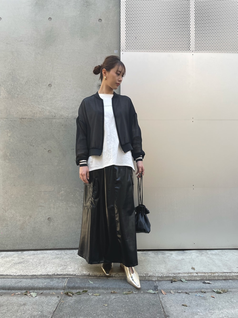 ブラック系のブルゾン、ブラック系のショルダーバッグ、ブラック系のスカートを着用したレディースの春コーディネートの2枚目の写真