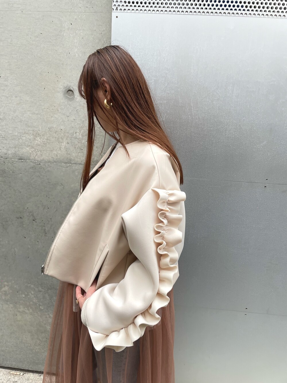 ホワイト系のブルゾン、ベージュ系のワンピースを着用したレディースの冬コーディネートの3枚目の写真