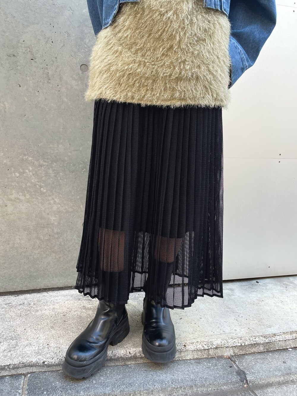 グリーン系のベスト、ブラック系のスカート、ブルー系のデニムジャケットを着用したレディースの冬コーディネートの5枚目の写真