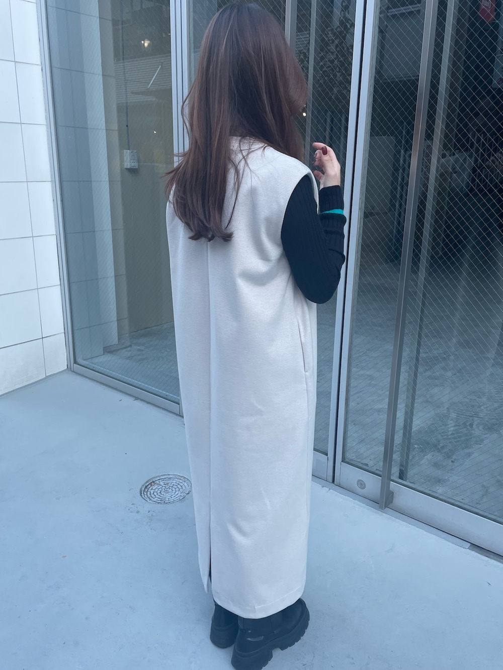 ブルー系のハンドバッグ、ブラック系のニット/セーター、ホワイト系のワンピースを着用したレディースの秋コーディネートの4枚目の写真