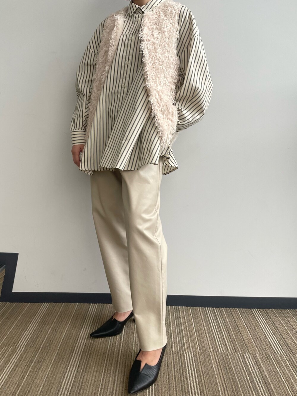 ベージュ系のベストを着用したレディースの冬コーディネートの4枚目の写真