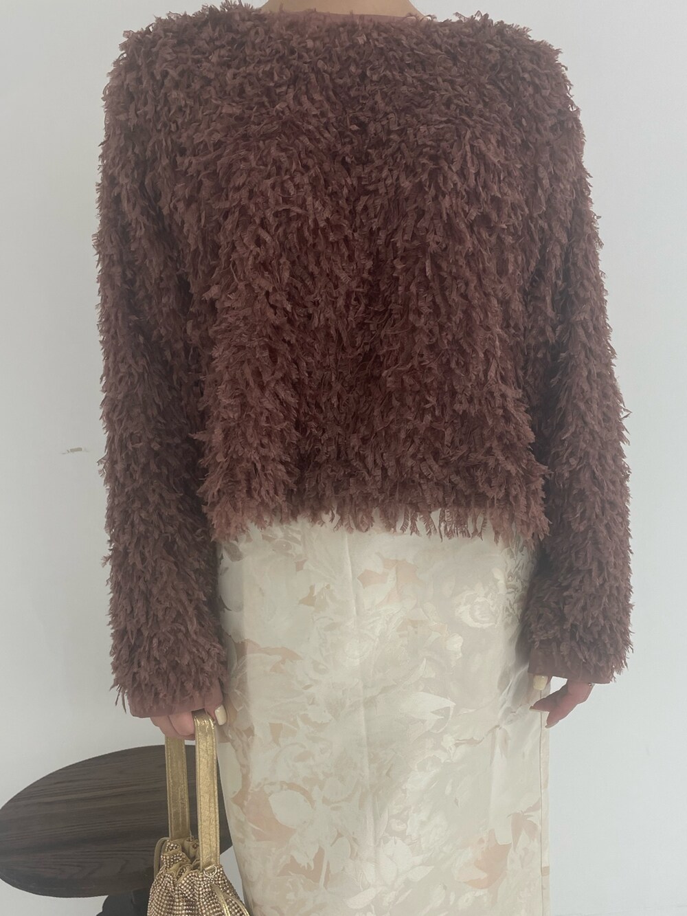 ゴールド系のトートバッグ、ホワイト系のスカート、ブラウン系のTシャツ/カットソーを着用したレディースの冬コーディネートの7枚目の写真