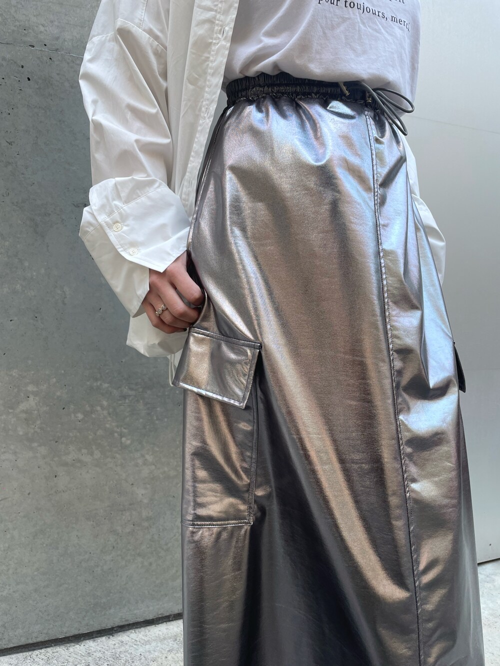 ホワイト系のスニーカー、ホワイト系のバッグ、シルバー系のスカートを着用したレディースの春コーディネートの8枚目の写真