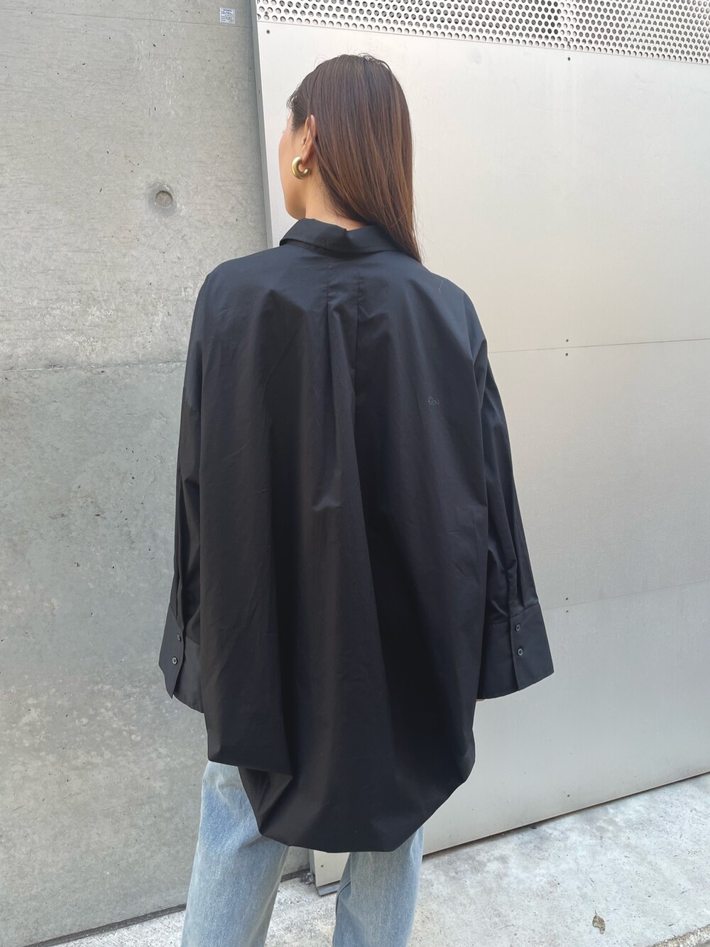 ブルー系のデニムパンツ、ブラック系のシャツ/ブラウスを着用したレディースの春コーディネートの4枚目の写真