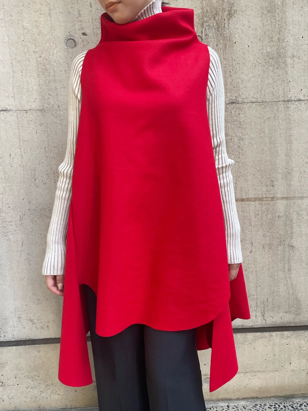 レッド系のベスト、ホワイト系のニット/セーター、ブラック系のその他パンツを着用したレディースの秋コーディネートの6枚目の写真