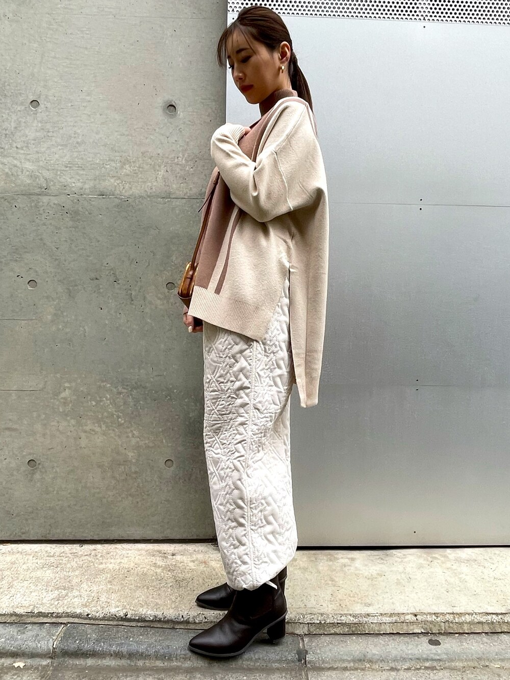 ブラウン系のショルダーバッグ、ベージュ系のニット/セーター、ホワイト系のその他パンツを着用したレディースの冬コーディネートの4枚目の写真