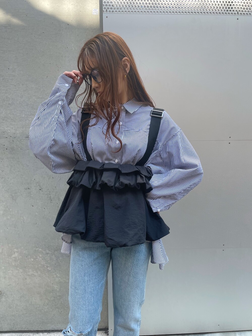 ブルー系のデニムパンツ、ブラック系のローファー、ブラック系のベストを着用したレディースの春コーディネートの2枚目の写真