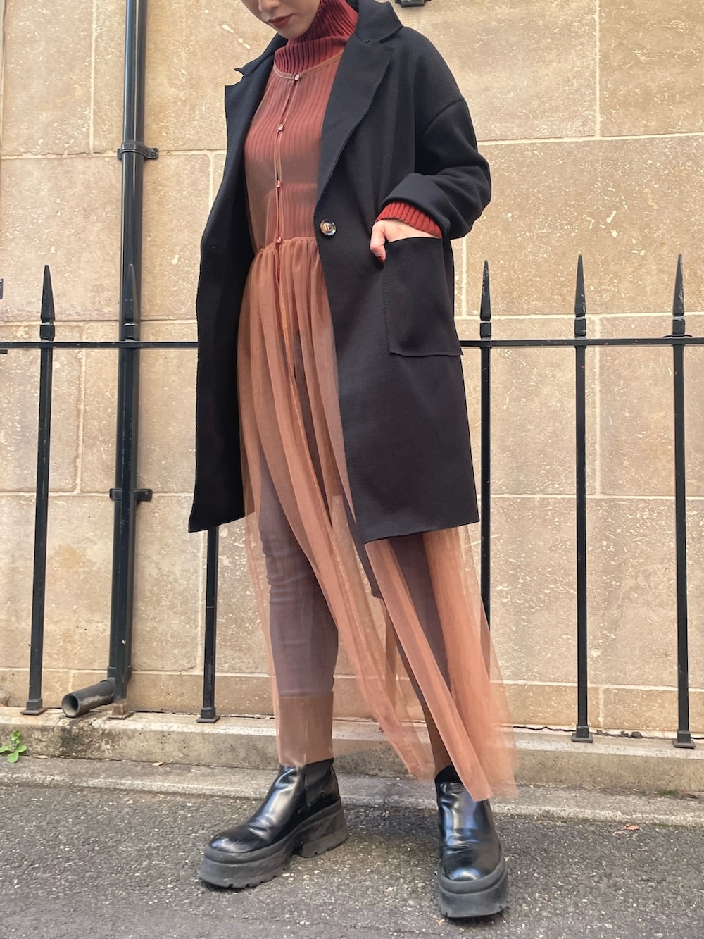 ベージュ系のワンピース、レッド系のニット/セーター、ブラック系のその他アウターを着用したレディースの秋コーディネートの2枚目の写真