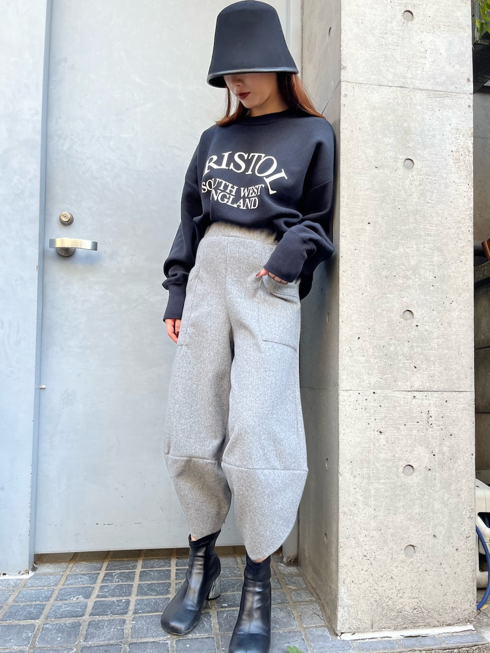 グレー系のその他パンツ、ブラック系のニット/セーター、ブラック系のハットを着用したレディースの冬コーディネートの10枚目の写真