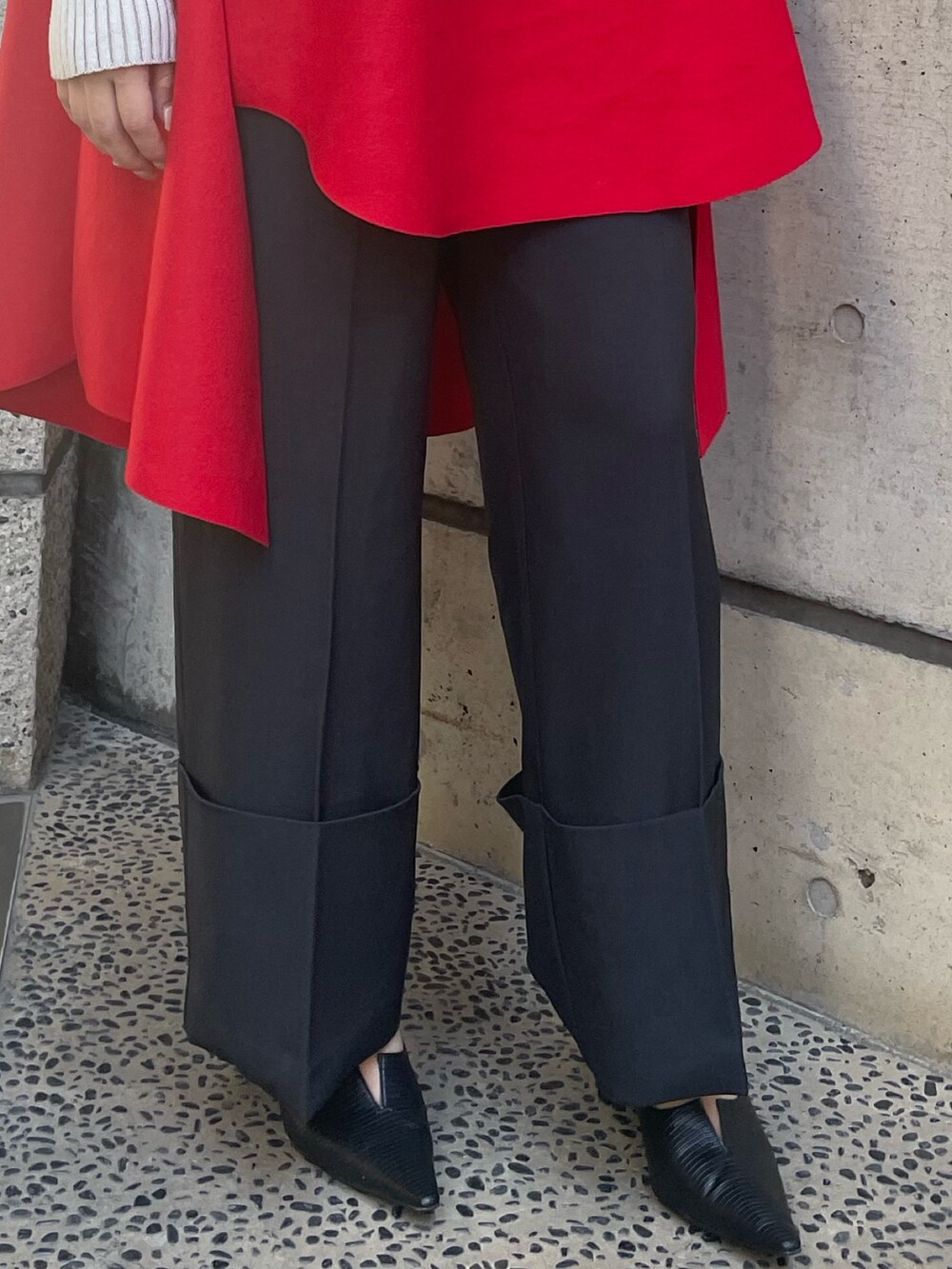 レッド系のベスト、ホワイト系のニット/セーター、ブラック系のその他パンツを着用したレディースの秋コーディネートの8枚目の写真