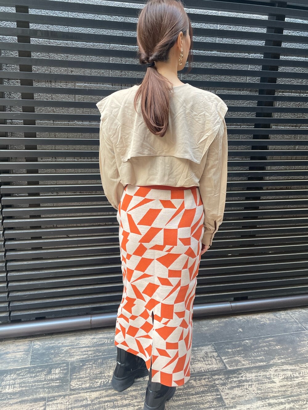 オレンジ系のスカートを着用したレディースの冬コーディネートの5枚目の写真