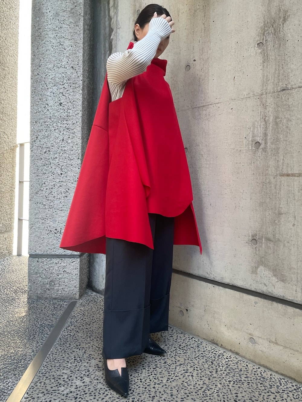 レッド系のベスト、ホワイト系のニット/セーター、ブラック系のその他パンツを着用したレディースの秋コーディネートの5枚目の写真