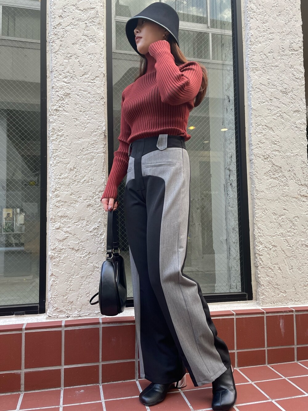 ブラック系のその他パンツ、ブラック系のショルダーバッグ、レッド系のニット/セーターを着用したレディースの冬コーディネートの4枚目の写真