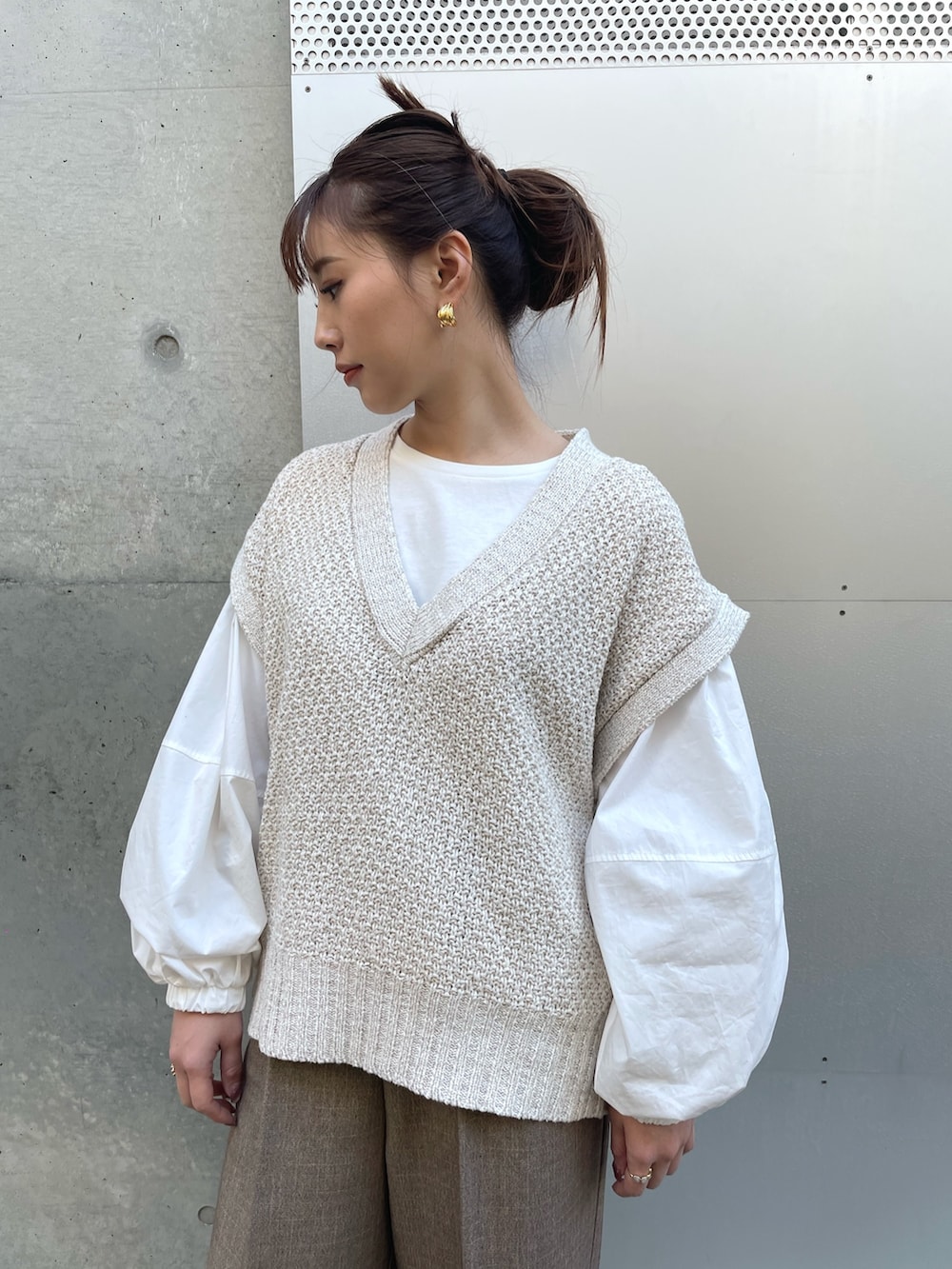 ホワイト系のTシャツ/カットソー、ホワイト系のベスト、ブラウン系のパンツを着用したレディースの冬コーディネートの4枚目の写真