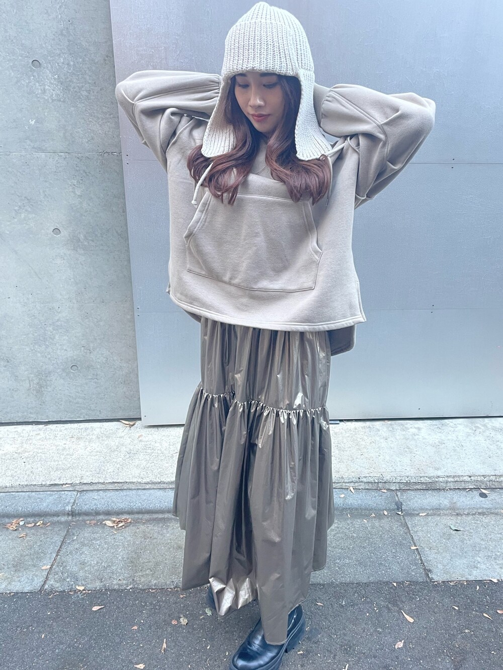 ゴールド系のスカート、ベージュ系のパーカー、ホワイト系のニットキャップ/ビーニーを着用したレディースの秋コーディネートの7枚目の写真