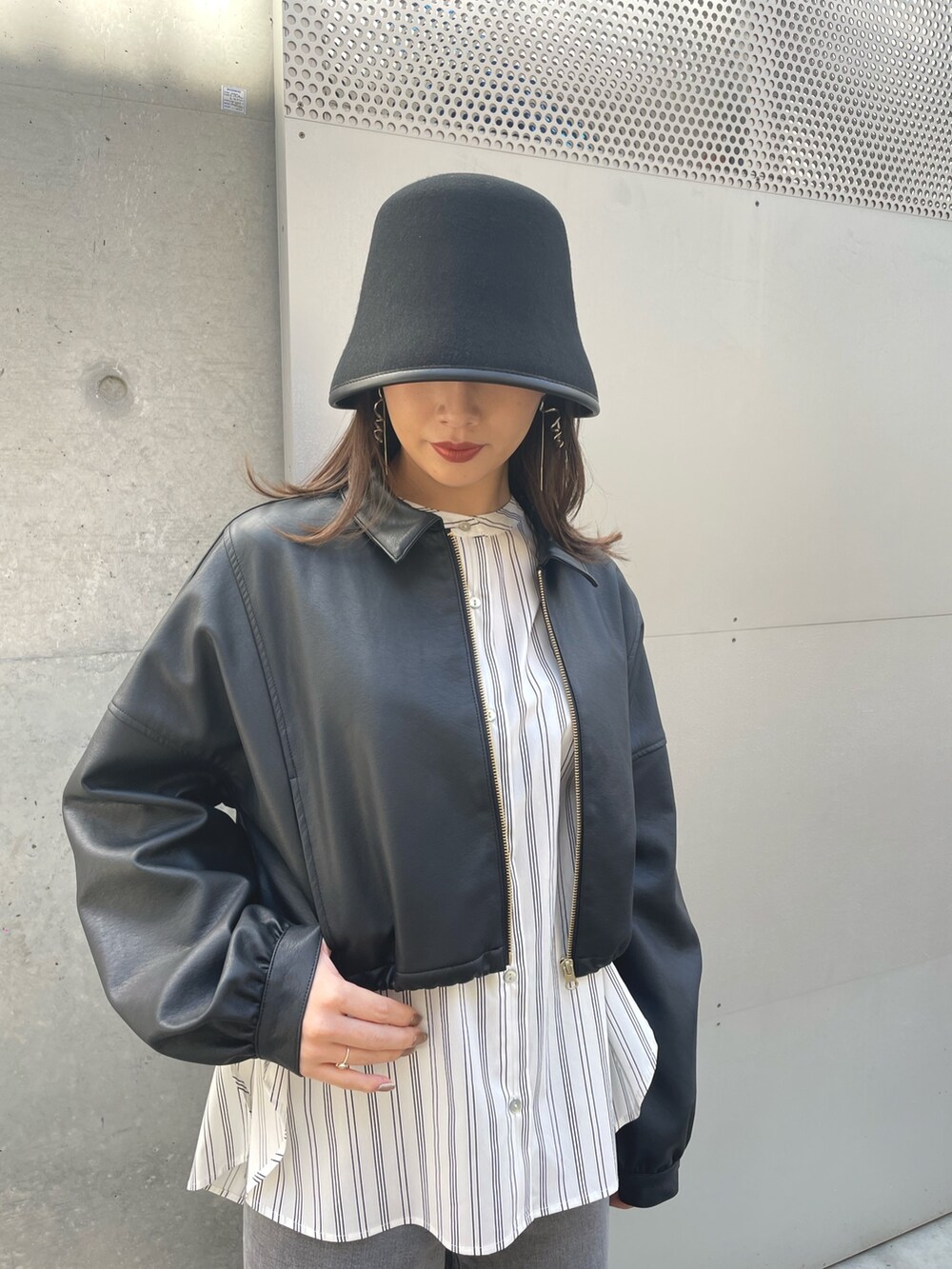 ホワイト系のシャツ/ブラウス、ブラック系のデニムパンツ、ブラック系のブルゾンを着用したレディースの春コーディネートの6枚目の写真