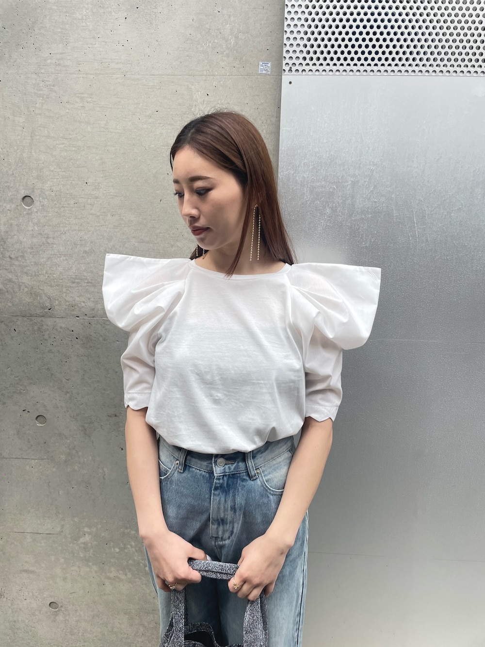 ホワイト系のTシャツ/カットソー、シルバー系のトートバッグ、ブルー系のデニムパンツを着用したレディースの春コーディネートの3枚目の写真